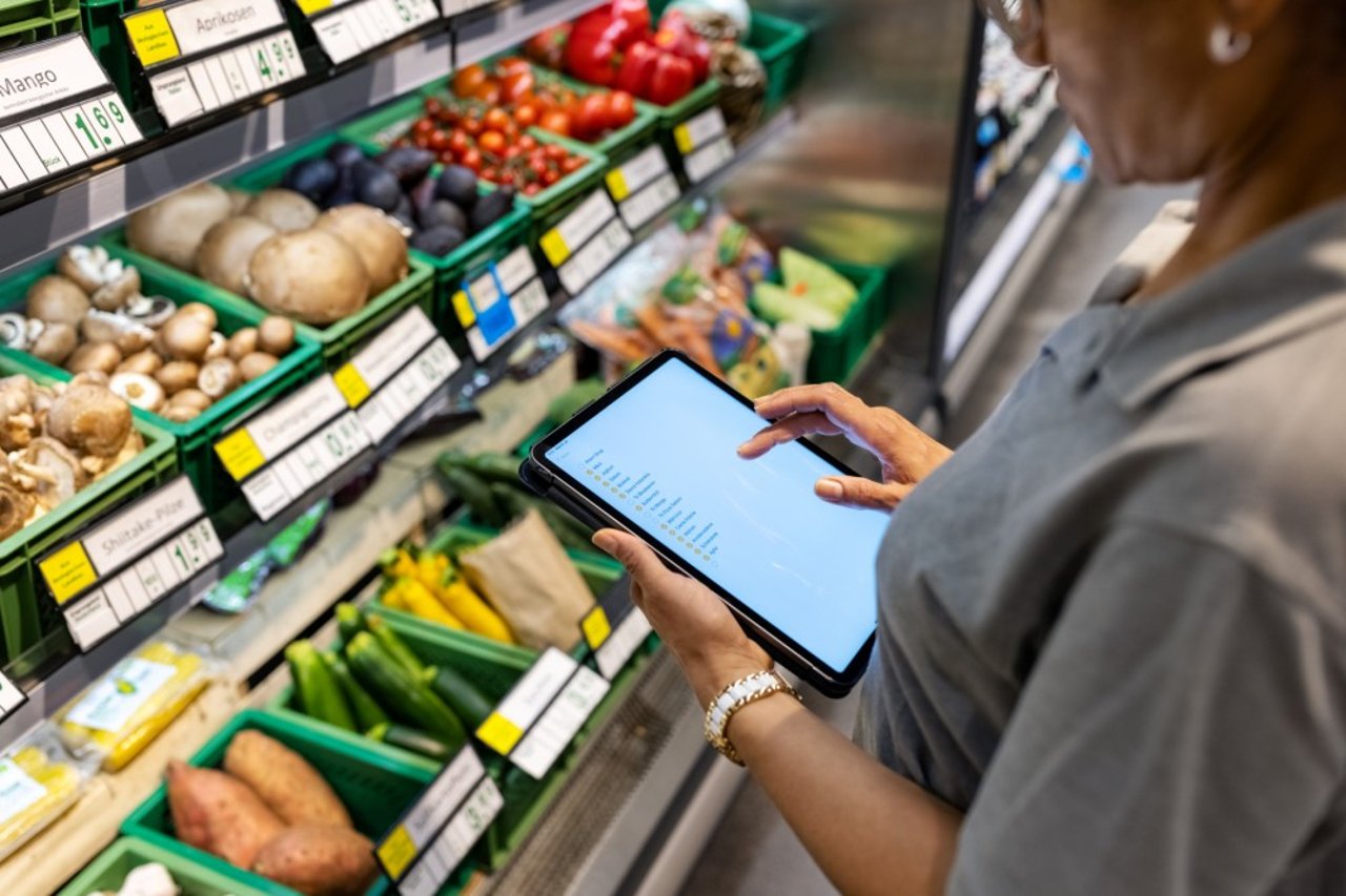 a woman grocery shopping and consulting her grocery list