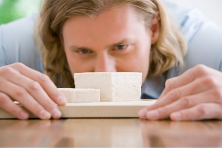 Hombre mira con curiosidad el tofu.