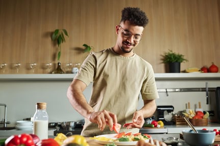 Hombre cocinando comida a base de plantas.