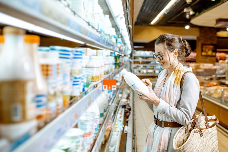 Una consumidora elige leche vegetal en un supermercado.