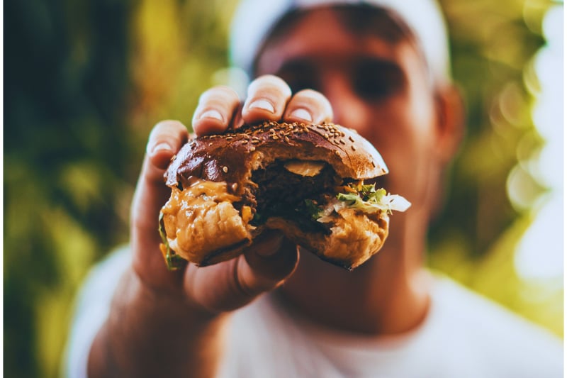 Un hombre muestra una hamburguesa vegetal